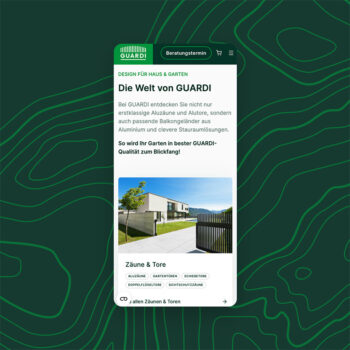 Auf dem Bildschirm eines Mobiltelefons wird die GUARDI Website angezeigt, die ein modernes Haus mit einem Metallzaun und einem Tor unter blauem Himmel zeigt. Auf der Seite werden Produkte für Haus und Garten vorgestellt, darunter Zäune und Tore.